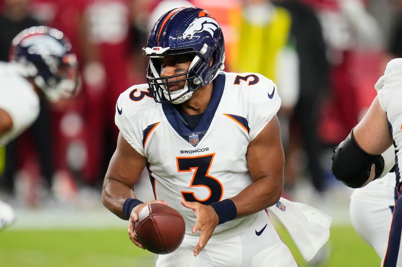 Denver Broncos quarterback Russell Wilson hands the ball off during the first half of an NFL preseason football game against the Arizona Cardinals, Friday, Aug. 11, 2023, in Glendale, Ariz. (AP Photo/Ross D. Franklin)