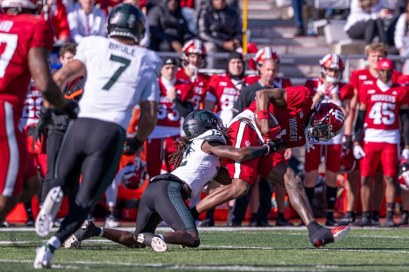 Nov 18, 2023; Bloomington, Indiana, USA; Indiana Hoosiers wide receiver Donaven McCulley (1) is tackled by Michigan State Spartans defensive back Chester Kimbrough (12) during the first quarter at Memorial Stadium. Mandatory Credit: Marc Lebryk-USA TODAY Sports