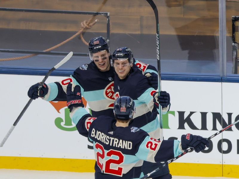 Jan 1, 2024; Seattle, Washington, USA; Seattle Kraken center Yanni Gourde (37, right) celebrates with right wing Eeli Tolvanen (20) and right wing Oliver Bjorkstrand (22) after scoring a goal against the Vegas Golden Knights during the third period in the 2024 Winter Classic ice hockey game at T-Mobile Park. Mandatory Credit: Joe Nicholson-USA TODAY Sports