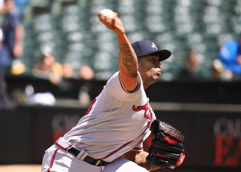 May 31, 2023; Oakland, California, USA; Atlanta Braves relief pitcher Raisel Iglesias (26) pitches the ball against the Oakland Athletics during the ninth inning at Oakland-Alameda County Coliseum. Mandatory Credit: Kelley L Cox-USA TODAY Sports