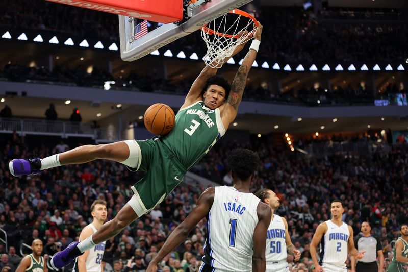 MILWAUKEE, WISCONSIN - DECEMBER 21: MarJon Beauchamp #3 of the Milwaukee Bucks dunks in front of Jonathan Isaac #1 of the Orlando Magic during the first half of a game at Fiserv Forum on December 21, 2023 in Milwaukee, Wisconsin. NOTE TO USER: User expressly acknowledges and agrees that, by downloading and or using this photograph, User is consenting to the terms and conditions of the Getty Images License Agreement. (Photo by Stacy Revere/Getty Images)