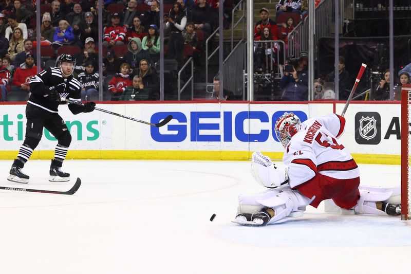 Mar 9, 2024; Newark, New Jersey, USA; Carolina Hurricanes goaltender Pyotr Kochetkov (52) makes a save on New Jersey Devils center Chris Tierney (11) during the second period at Prudential Center. Mandatory Credit: Ed Mulholland-USA TODAY Sports