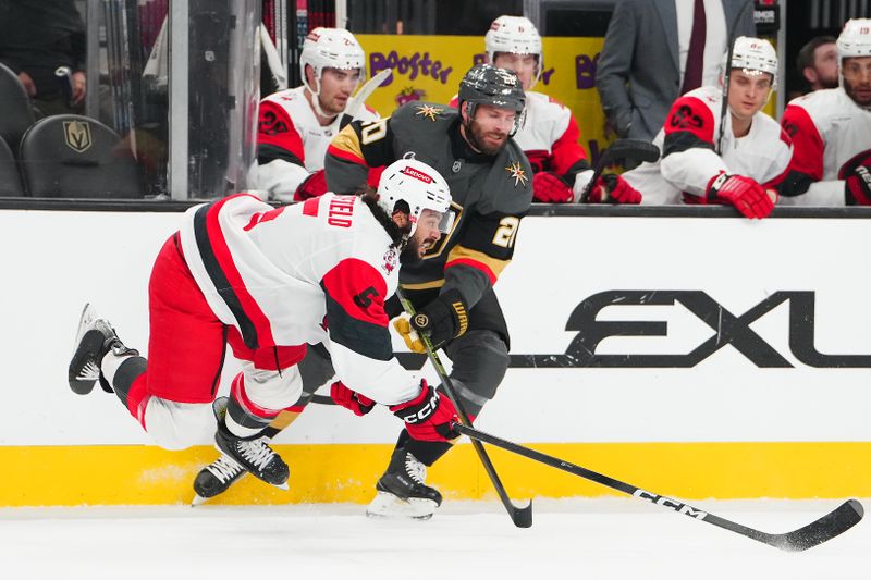 Oct 20, 2025; Las Vegas, Nevada, USA; Carolina Hurricanes defenseman Jalen Chatfield (5) clears the puck away from Vegas Golden Knights left wing Brandon Saad (20) during the first period at T-Mobile Arena. Mandatory Credit: Stephen R. Sylvanie-Imagn Images