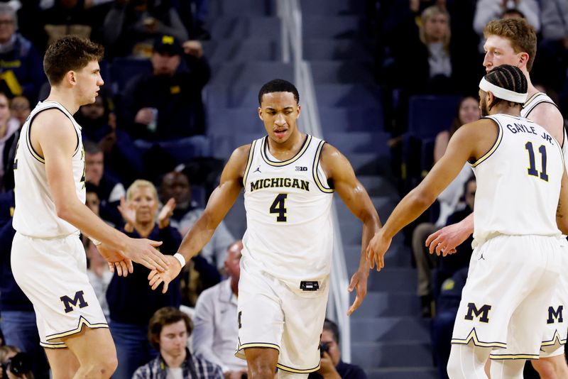 Feb 27, 2025; Ann Arbor, Michigan, USA; Michigan Wolverines guard Nimari Burnett (4) receives congratulations from teammates during the second half against the Rutgers Scarlet Knights  at Crisler Center. Mandatory Credit: Rick Osentoski-Imagn Images