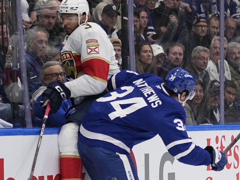 May 5, 2025; Toronto, Ontario, CAN; Toronto Maple Leafs forward Auston Matthews (34) checks Florida Panthers defenseman Seth Jones (3) into the boards during the first period of game one in the second round of the 2025 Stanley Cup Playoffs at Scotiabank Arena. Mandatory Credit: John E. Sokolowski-Imagn Images