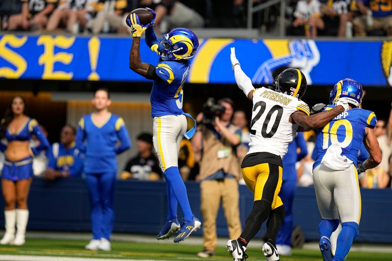 Los Angeles Rams wide receiver Tutu Atwell, left, makes a catch before running in for touchdown as Pittsburgh Steelers cornerback Patrick Peterson, center, defends and wide receiver Cooper Kupp watches during the first half of an NFL football game Sunday, Oct. 22, 2023, in Inglewood, Calif. (AP Photo/Gregory Bull)