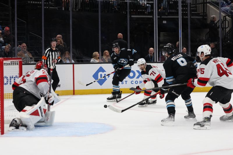 Dec 19, 2025; Salt Lake City, Utah, USA; Utah Mammoth center Nick Schmaltz (8) centers a pass to right wing Clayton Keller (9) as New Jersey Devils defenseman Jonas Siegenthaler (71) and goaltender Jacob Markstrom (25) defend during the second period with defenseman Colton White (45) at Delta Center. Mandatory Credit: Rob Gray-Imagn Images