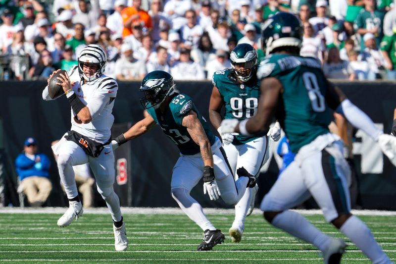 Cincinnati Bengals quarterback Joe Burrow, left, runs for yardage as Philadelphia Eagles linebacker Zack Baun (53) tries to stop him during the second half of an NFL football game, Sunday, Oct. 27, 2024 in Cincinnati. (AP Photo/Jeff Dean)