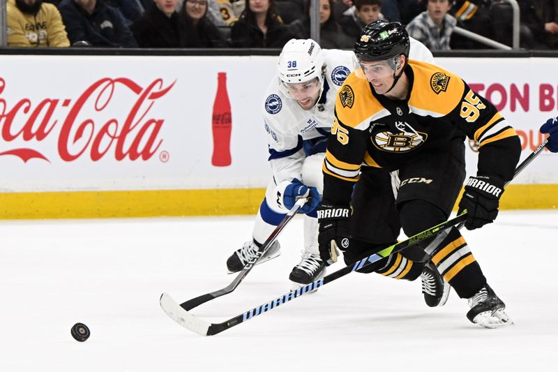 Jan 14, 2025; Boston, Massachusetts, USA; Tampa Bay Lightning left wing Brandon Hagel (38) and Boston Bruins center Vinni Lettieri (95) race for the puck during the first period at the TD Garden. Mandatory Credit: Brian Fluharty-Imagn Images