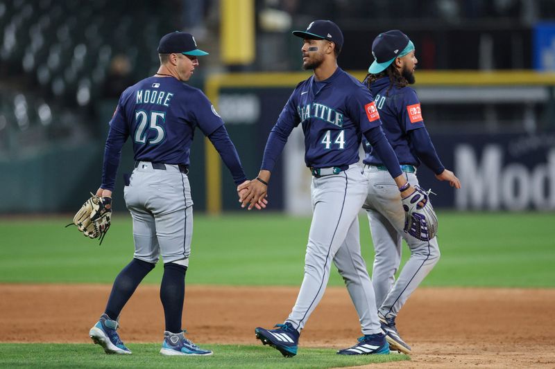 May 19, 2025; Chicago, Illinois, USA; Seattle Mariners center fielder Julio Rodriguez (44) and second baseman Dylan Moore (25) celebrate team's win against the Chicago White Sox in a baseball game at Rate Field. Mandatory Credit: Kamil Krzaczynski-Imagn Images