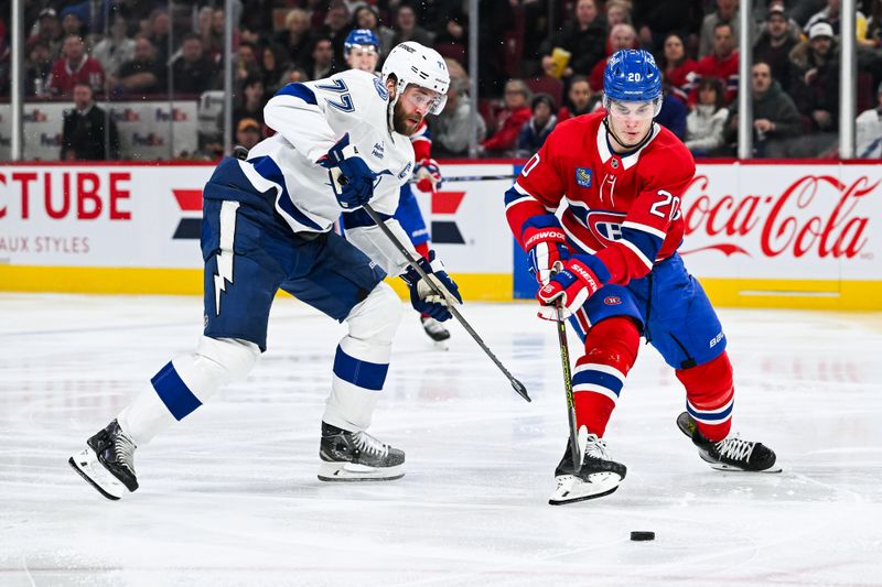 Jan 21, 2025; Montreal, Quebec, CAN; Montreal Canadiens left wing Juraj Slafkovsky (20) plays the puck against Tampa Bay Lightning defenseman Victor Hedman (77) during the third period at Bell Centre. Mandatory Credit: David Kirouac-Imagn Images