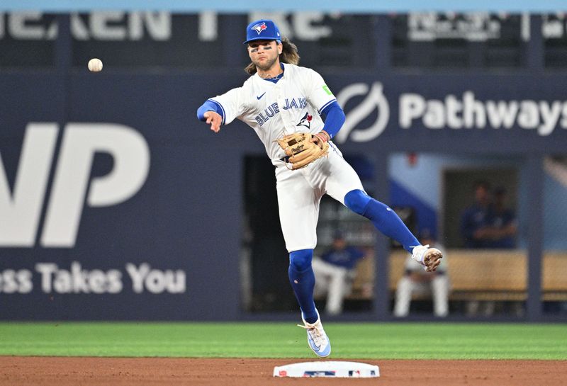 Apr 10, 2024; Toronto, Ontario, CAN;  Toronto Blue Jays shortstop Bo Bichette (11) throws out Seattle Mariners third baseman Luis Urias (not shown) in the fifth inning at Rogers Centre. Mandatory Credit: Dan Hamilton-USA TODAY Sports