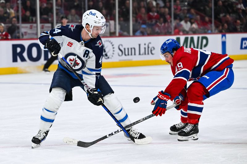Oct 28, 2023; Montreal, Quebec, CAN; Winnipeg Jets defenseman Josh Morrissey (44) defends the puck against Montreal Canadiens left wing Rafael Harvey-Pinard (49) during the second period at Bell Centre. Mandatory Credit: David Kirouac-USA TODAY Sports
