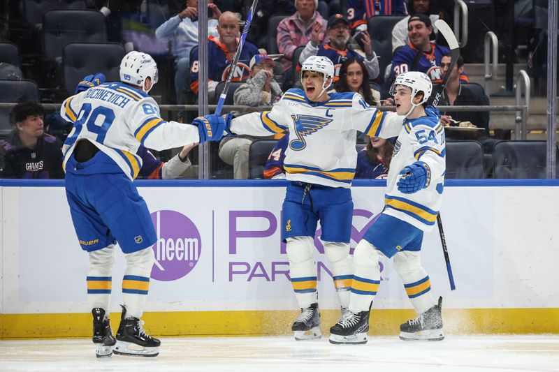 Nov 22, 2025; Elmont, New York, USA;  St. Louis Blues center Brayden Schenn (10) celebrates with left wing Pavel Buchnevich (89) and right wing Dalibor Dvorsky (54) after scoring a goal in the first period against the New York Islanders at UBS Arena. Mandatory Credit: Wendell Cruz-Imagn Images