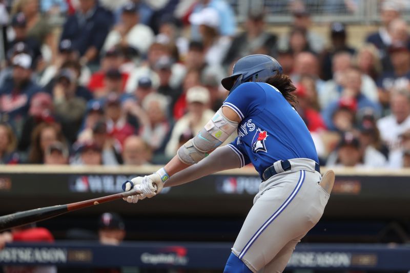 Oct 4, 2023; Minneapolis, Minnesota, USA; Toronto Blue Jays shortstop Bo Bichette (11) hits a single in the first inning against the Minnesota Twins during game two of the Wildcard series for the 2023 MLB playoffs at Target Field. Mandatory Credit: Jesse Johnson-USA TODAY Sports