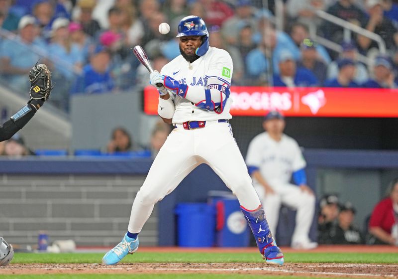 Jun 30, 2024; Toronto, Ontario, CAN; Toronto Blue Jays first base Vladimir Guerrero Jr. (27) gets hit with a pitch against the New York Yankees during the third inning at Rogers Centre. Mandatory Credit: Nick Turchiaro-USA TODAY Sports