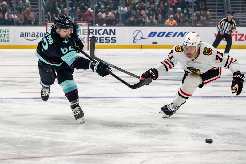 Nov 14, 2024; Seattle, Washington, USA;  Seattle Kraken defenseman Brandon Montour (62) shoots the puck against Chicago Blackhawks forward Taylor Hall (71) during the first period at Climate Pledge Arena. Mandatory Credit: Stephen Brashear-Imagn Images