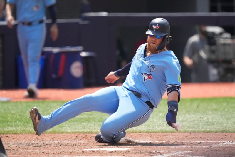 Jul 21, 2024; Toronto, Ontario, CAN; Toronto Blue Jays first baseman Justin Turner (2) slides into home plate to score the winning run against the Detroit Tigers during the sixth inning at Rogers Centre. Mandatory Credit: John E. Sokolowski-USA TODAY Sports