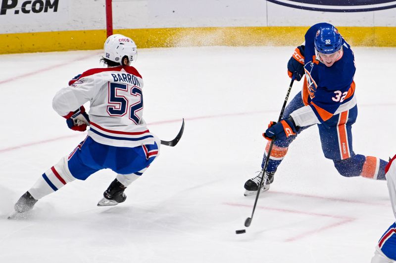 Apr 11, 2024; Elmont, New York, USA; New York Islanders center Kyle MacLean (32) attempts a shot defended by Montreal Canadiens defenseman Justin Barron (52)  during the second period at UBS Arena. Mandatory Credit: Dennis Schneidler-USA TODAY Sports