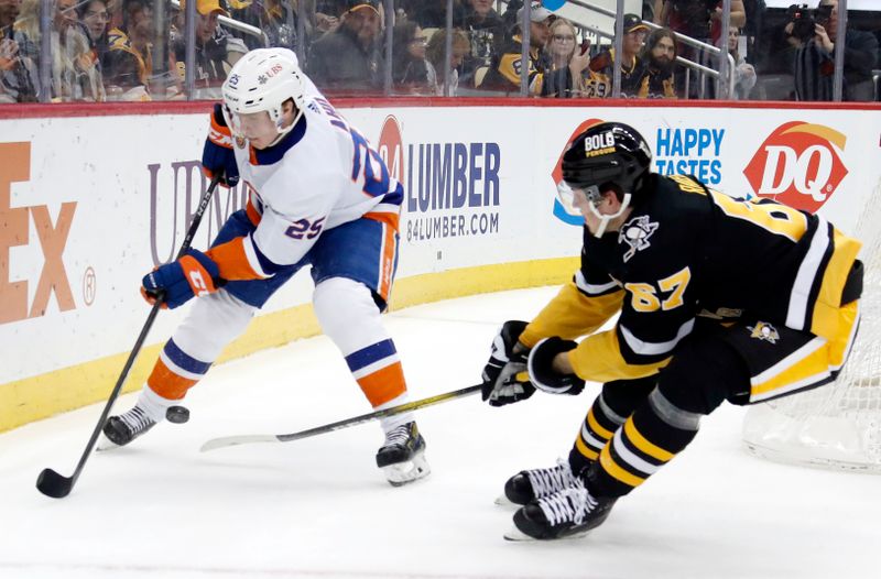 Mar 9, 2023; Pittsburgh, Pennsylvania, USA;  New York Islanders defenseman Sebastian Aho (25) moves the puck against Pittsburgh Penguins right wing Rickard Rakell (67) during the first period at PPG Paints Arena. Mandatory Credit: Charles LeClaire-USA TODAY Sports