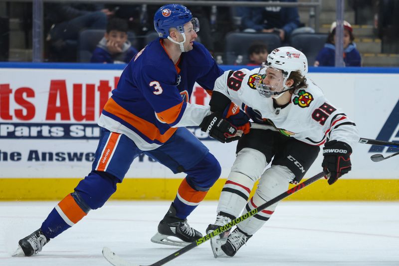 Apr 2, 2024; Elmont, New York, USA; Chicago Blackhawks center Connor Bedard (98) and New York Islanders defenseman Adam Pelech (3) moving toward the puck during the third period at UBS Arena. Mandatory Credit: Thomas Salus-USA TODAY Sports