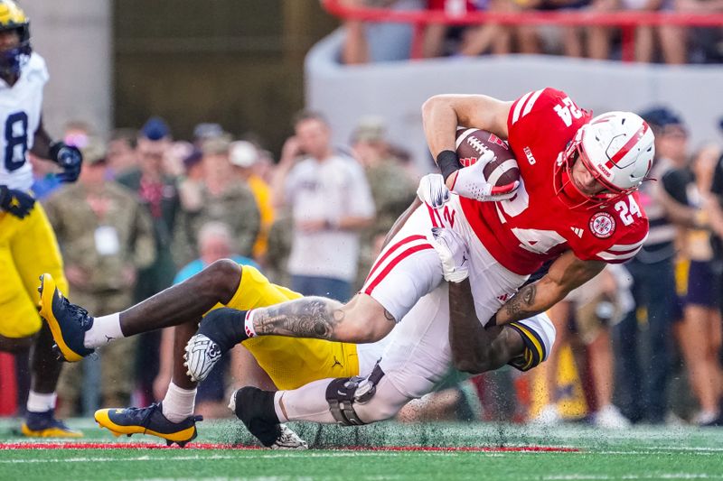 Sep 30, 2023; Lincoln, Nebraska, USA; Nebraska Cornhuskers tight end Thomas Fidone II (24) is tackled by Michigan Wolverines defensive back Makari Paige (7) during the fourth quarter at Memorial Stadium. Mandatory Credit: Dylan Widger-USA TODAY Sports