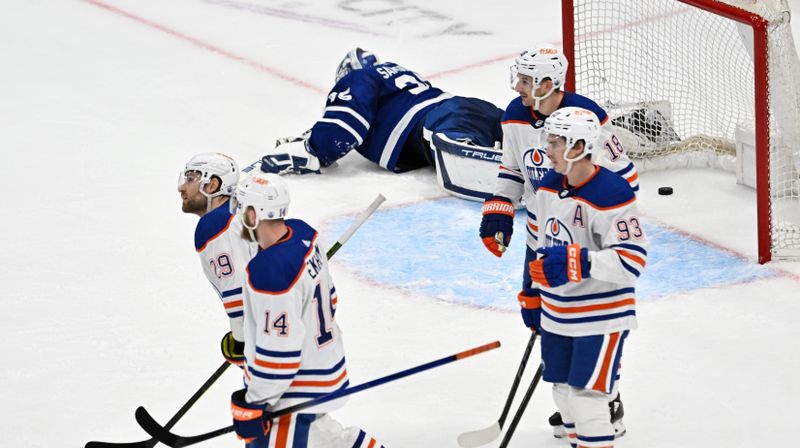 Mar 23, 2024; Toronto, Ontario, CAN; Edmonton Oilers players celebrate a goal by forward Leon Draisaitl (29) as Toronto Maple Leafs goal Ilya Samsonov (35) lies injured on the ice in the third period at Scotiabank Arena. Mandatory Credit: Dan Hamilton-USA TODAY Sports