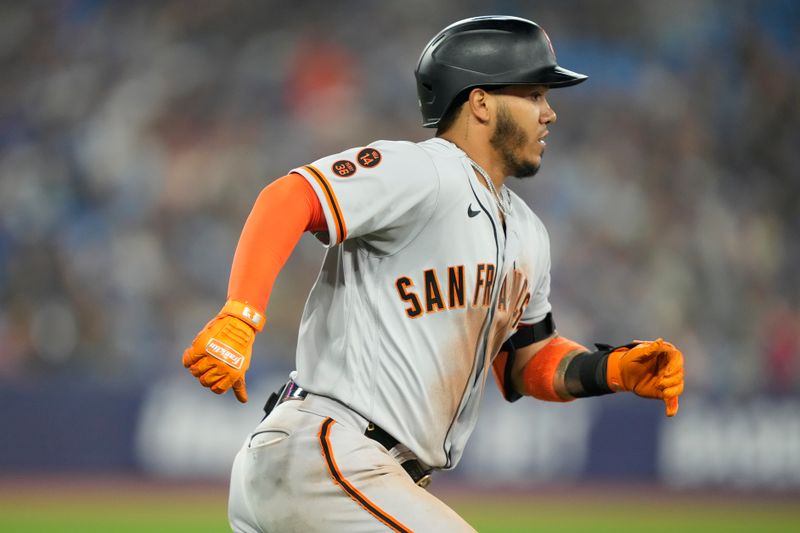 Jun 27, 2023; Toronto, Ontario, CAN; San Francisco Giants second baseman Thairo Estrada (39) runs to first base on his two run double against the Toronto Blue Jays during the ninth inning at Rogers Centre. Mandatory Credit: John E. Sokolowski-USA TODAY Sports