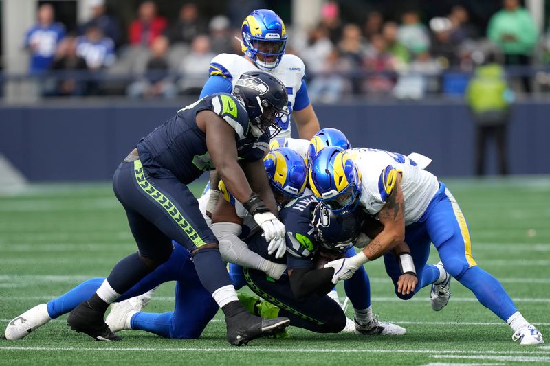 Seattle Seahawks quarterback Geno Smith, bottom middle, is tackled against the Los Angeles Rams during the first half of an NFL football game in Seattle, Sunday, Nov. 3, 2024. (AP Photo/Stephen Brashear)