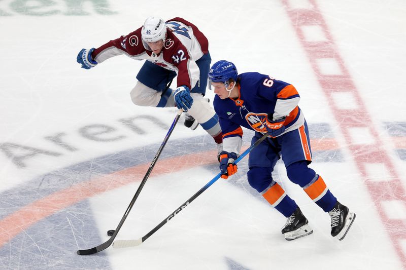 Dec 4, 2025; Elmont, New York, USA; Colorado Avalanche defenseman Josh Manson (42) knocks the puck away from New York Islanders center Calum Ritchie (64) during the second period at UBS Arena. Mandatory Credit: Brad Penner-Imagn Images