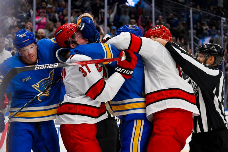 Oct 19, 2024; St. Louis, Missouri, USA;  St. Louis Blues defenseman Ryan Suter (22) and St. Louis Blues center Brayden Schenn (10) fight Carolina Hurricanes right wing Andrei Svechnikov (37) and center Jordan Staal (11) during the third period at Enterprise Center. Mandatory Credit: Jeff Curry-Imagn Images