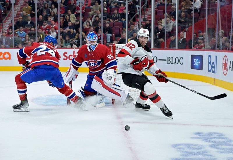 Sep 24, 2024; Montreal, Quebec, CAN; New Jersey Devils defenseman Santeri Hatakka (82) plays the puck and Montreal Canadiens goalie Connor Hughes (95) defends with teammate defenseman Logan Mailloux (24) during the second period at the Bell Centre. Mandatory Credit: Eric Bolte-Imagn Images