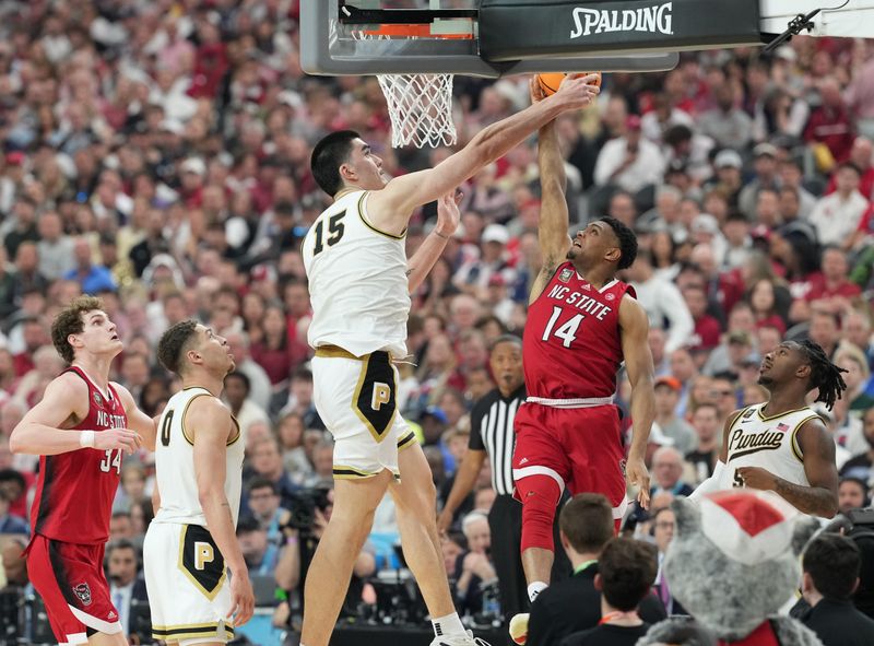 Apr 6, 2024; Glendale, AZ, USA; Purdue Boilermakers center Zach Edey (15) blocks a shot by North Carolina State Wolfpack guard Casey Morsell (14) in the semifinals of the men's Final Four of the 2024 NCAA Tournament at State Farm Stadium. Mandatory Credit: Robert Deutsch-USA TODAY Sports