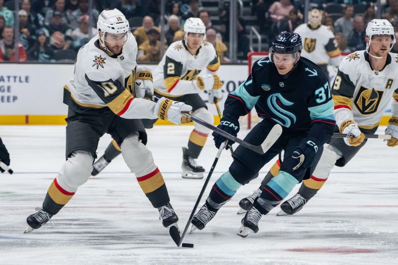 Nov 8, 2024; Seattle, Washington, USA;  Vegas Golden Knights forward Nicolas Roy (10) and Seattle Kraken forward Yanni Gourde (37) battle for the puck during the first period at Climate Pledge Arena. Mandatory Credit: Stephen Brashear-Imagn Images