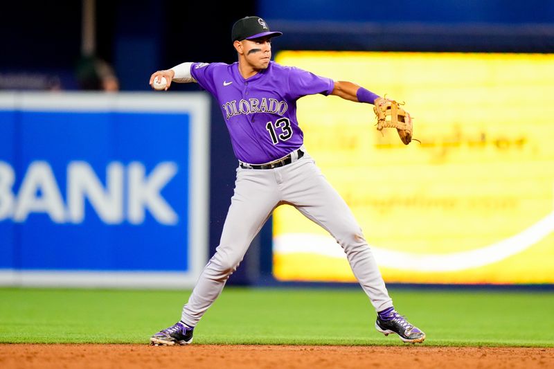 Jul 23, 2023; Miami, Florida, USA; Colorado Rockies second baseman Alan Trejo (13) throws the ball to first base against the Miami Marlins during the third inning at loanDepot Park. Mandatory Credit: Rich Storry-USA TODAY Sports