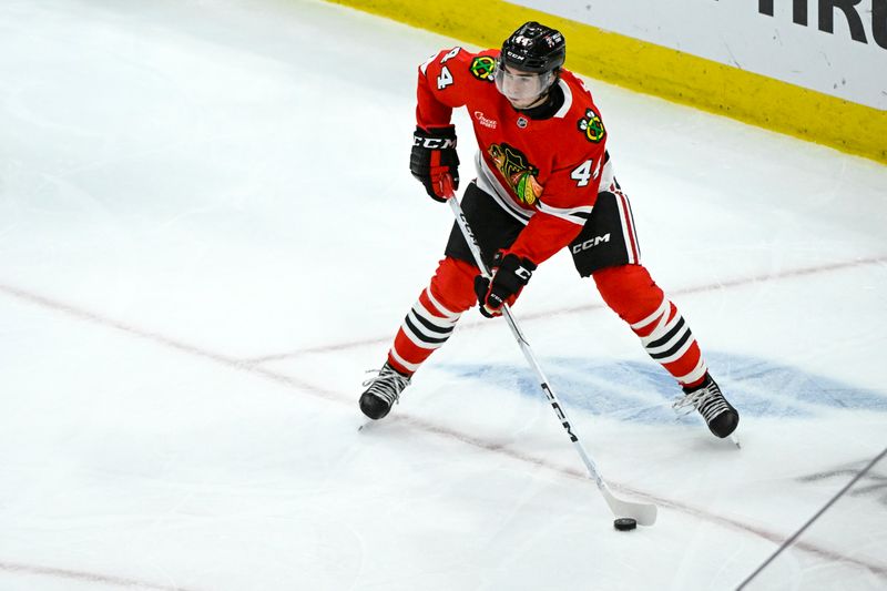 Jan 20, 2025; Chicago, Illinois, USA;  Chicago Blackhawks defenseman Wyatt Kaiser (44) moves the puck against Carolina Hurricanes during the third period at the United Center. Mandatory Credit: Matt Marton-Imagn Images


