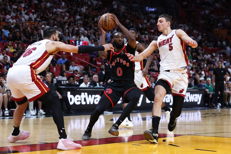 MIAMI, FLORIDA - APRIL 14: Javon Freeman-Liberty #0 of the Toronto Raptors drives against Caleb Martin #16 and Nikola Jovic #5 of the Miami Heat during the third quarter of the game at Kaseya Center on April 14, 2024 in Miami, Florida. NOTE TO USER: User expressly acknowledges and agrees that, by downloading and or using this photograph, User is consenting to the terms and conditions of the Getty Images License Agreement. (Photo by Megan Briggs/Getty Images)