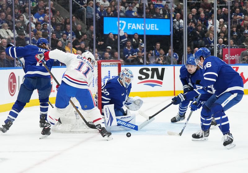 Nov 9, 2024; Toronto, Ontario, CAN; Montreal Canadiens right wing Brendan Gallagher (11) battles for the puck with Toronto Maple Leafs defenseman Simon Benoit (2) during the second period at Scotiabank Arena. Mandatory Credit: Nick Turchiaro-Imagn Images