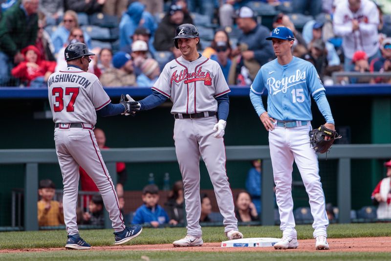 Apr 16, 2023; Kansas City, Missouri, USA; Atlanta Braves first baseman Matt Olson (28) slaps hands with Atlanta Braves third base coach Ron Washington (37) after hitting an in park triple during the third inning against the Kansas City Royals at Kauffman Stadium. Mandatory Credit: William Purnell-USA TODAY Sports