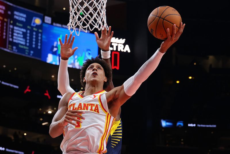 ATLANTA, GEORGIA - OCTOBER 08:  Jalen Johnson #1 of the Atlanta Hawks drives against Bennedict Mathurin #00 of the Indiana Pacers during the first quarter at State Farm Arena on October 08, 2024 in Atlanta, Georgia.  NOTE TO USER: User expressly acknowledges and agrees that, by downloading and/or using this photograph, user is consenting to the terms and conditions of the Getty Images License Agreement.  (Photo by Kevin C. Cox/Getty Images)