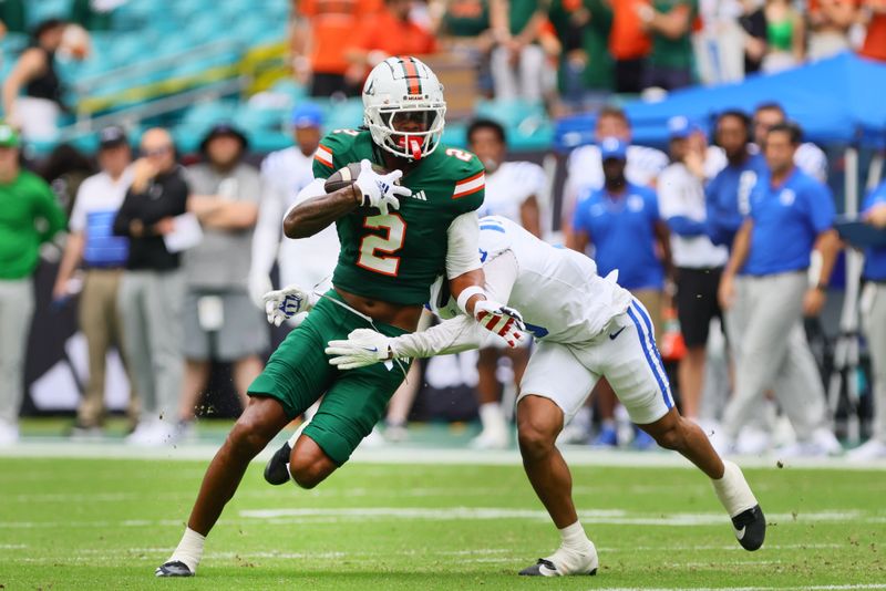 Nov 2, 2024; Miami Gardens, Florida, USA; Miami Hurricanes wide receiver Isaiah Horton (2) runs with the football against Duke Blue Devils cornerback Kimari Robinson (5) during the first quarter at Hard Rock Stadium. Mandatory Credit: Sam Navarro-Imagn Images