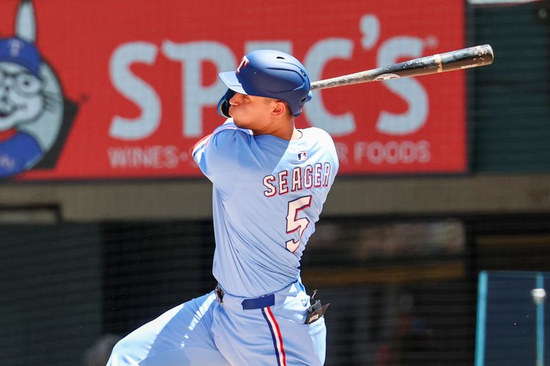 May 4, 2025; Arlington, Texas, USA;  Texas Rangers shortstop Corey Seager (5) hits a two-run single during the third inning against the Seattle Mariners at Globe Life Field. Mandatory Credit: Kevin Jairaj-Imagn Images