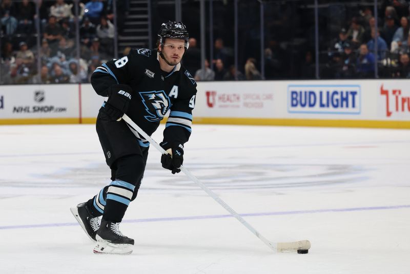 Apr 14, 2026; Salt Lake City, Utah, USA; Utah Mammoth defenseman Mikhail Sergachev (98) plays the puck against the Winnipeg Jets during the first period at Delta Center. Mandatory Credit: Rob Gray-Imagn Images