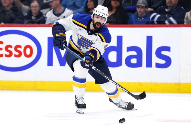 Apr 7, 2025; Winnipeg, Manitoba, CAN; St. Louis Blues defenseman Nick Leddy (4) shoots the puck against the Winnipeg Jets in the second period  at Canada Life Centre. Mandatory Credit: James Carey Lauder-Imagn Images