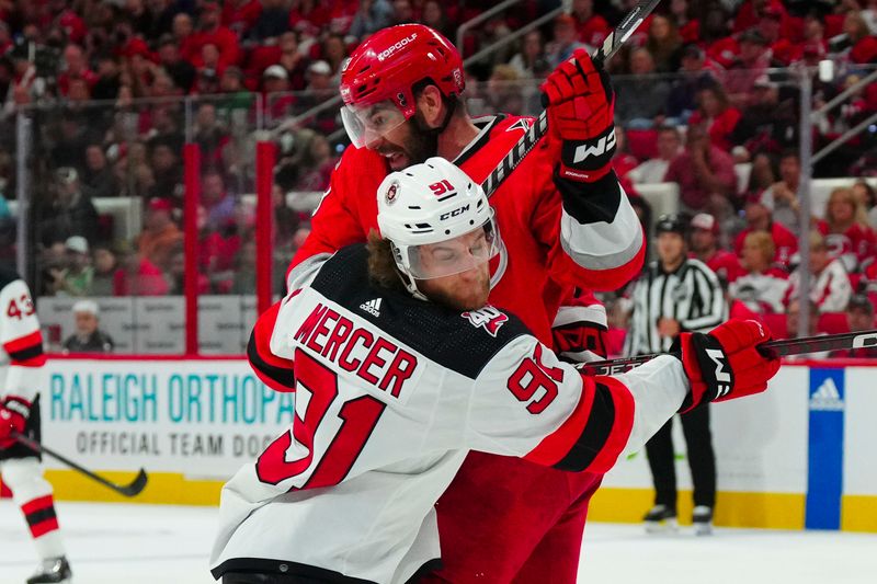 May 11, 2023; Raleigh, North Carolina, USA; New Jersey Devils center Dawson Mercer (91) battles against Carolina Hurricanes left wing Jordan Martinook (48) during the second period in game five of the second round of the 2023 Stanley Cup Playoffs at PNC Arena. Mandatory Credit: James Guillory-USA TODAY Sports