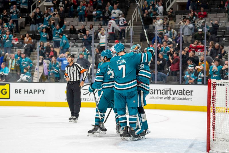 Nov 27, 2023; San Jose, California, USA; San Jose Sharks center Nico Sturm (7) and San Jose Sharks defenseman Mario Ferraro (38) celebrate with San Jose Sharks goaltender Mackenzie Blackwood (29) after the game against the Washington Capitals at SAP Center at San Jose. Mandatory Credit: Neville E. Guard-USA TODAY Sports