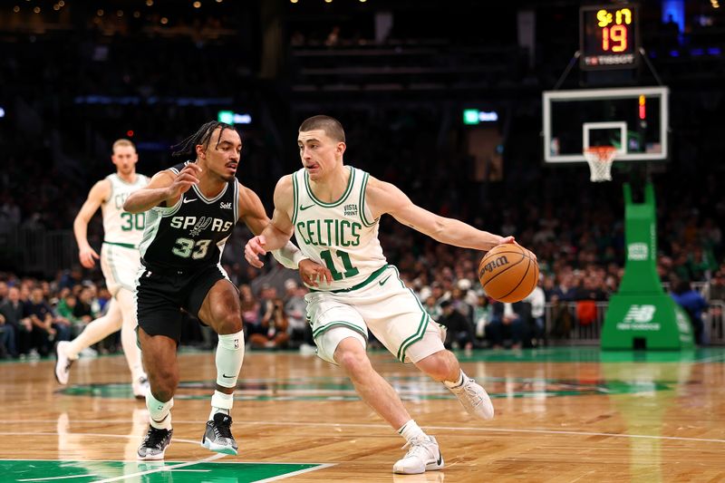 BOSTON, MASSACHUSETTS - JANUARY 17: Payton Pritchard #11 of the Boston Celtics drives to the basket past Tre Jones #33 of the San Antonio Spurs  at TD Garden on January 17, 2024 in Boston, Massachusetts. NOTE TO USER: User expressly acknowledges and agrees that, by downloading and or using this photograph, user is consenting to the terms and conditions of the Getty Images License Agreement.  (Photo by Maddie Meyer/Getty Images)