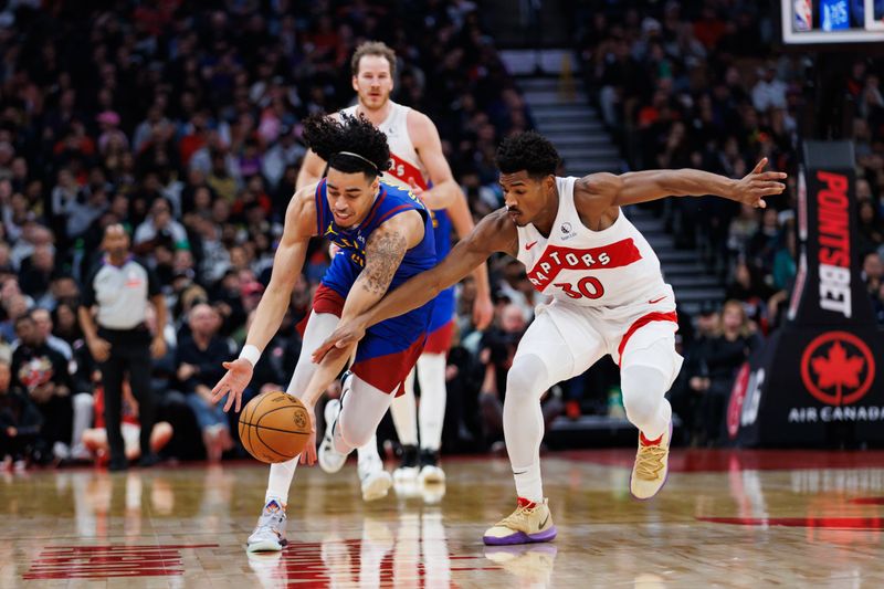 TORONTO, CANADA - OCTOBER 28: Julian Strawther #3 of the Denver Nuggets and Ochai Agbaji #30 of the Toronto Raptors reach for a loose ball during the first half of their NBA game at Scotiabank Arena on October 28, 2024 in Toronto, Ontario, Canada. NOTE TO USER: User expressly acknowledges and agrees that, by downloading and or using this photograph, User is consenting to the terms and conditions of the Getty Images License Agreement. (Photo by Cole Burston/Getty Images)