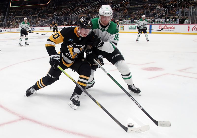 Nov 11, 2024; Pittsburgh, Pennsylvania, USA;  Pittsburgh Penguins center Lars Eller (20) moves the puck as Dallas Stars defenseman Thomas Harley (55) pressures during the third period at PPG Paints Arena. Mandatory Credit: Charles LeClaire-Imagn Images