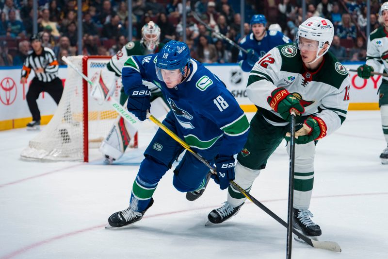 Apr 12, 2025; Vancouver, British Columbia, CAN; Minnesota Wild forward Matt Boldy (12) battles with Vancouver Canucks forward Drew O'Connor (18) in the second period at Rogers Arena. Mandatory Credit: Bob Frid-Imagn Images